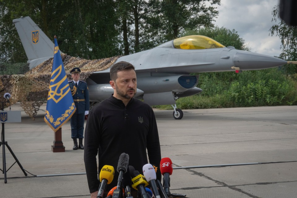 President Zelenskyy answering media questions in front of Ukrainian F-16 fighter jets.