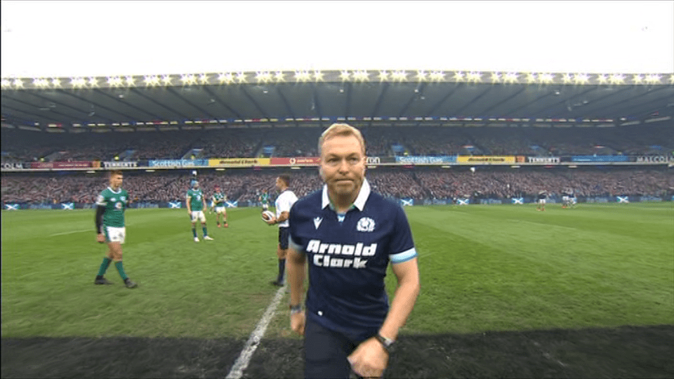 Man in Scotland rugby jersey on field.