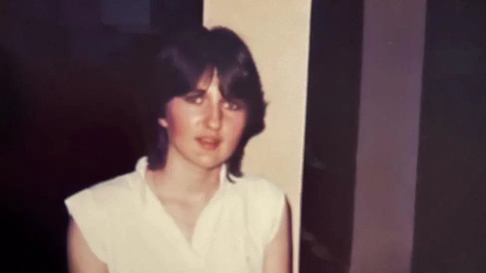 Photo of a young woman with short dark hair wearing a white shirt.
