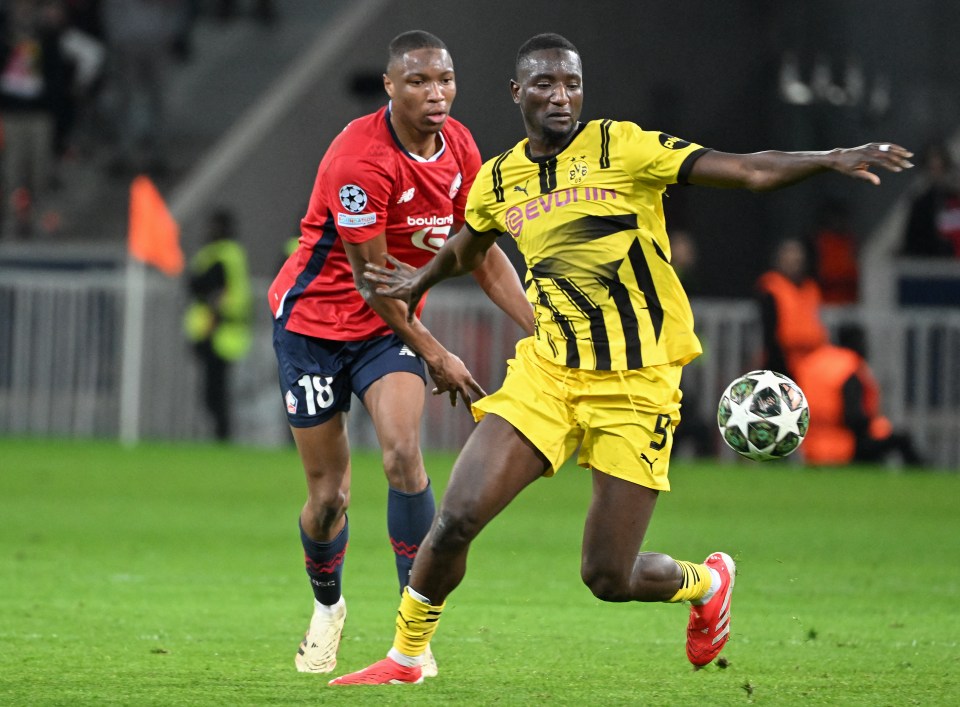 Sehrou Guirassy (Borussia Dortmund) and Bafode Diakite (Lille) competing for the ball during a UEFA Champions League match.