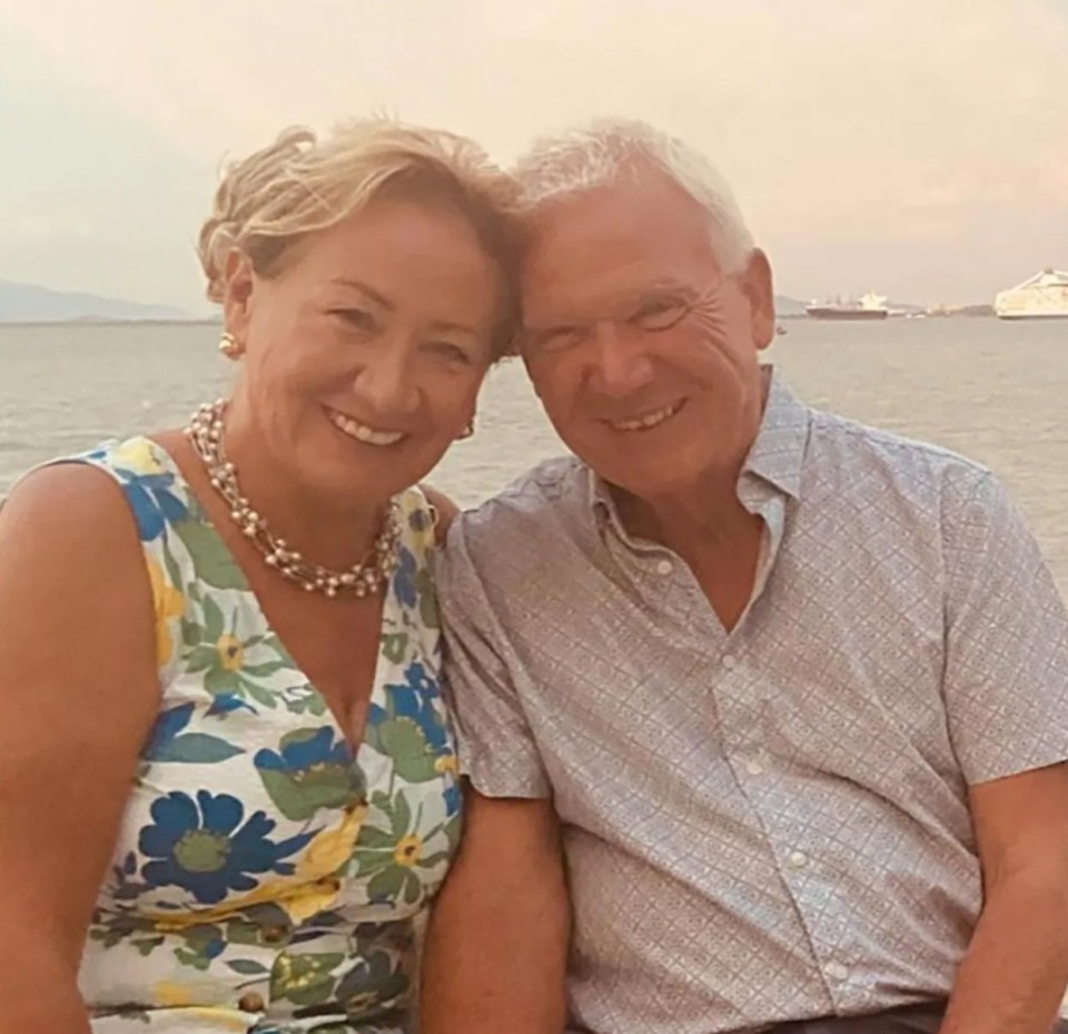 Photo of a smiling older couple sitting together outdoors.