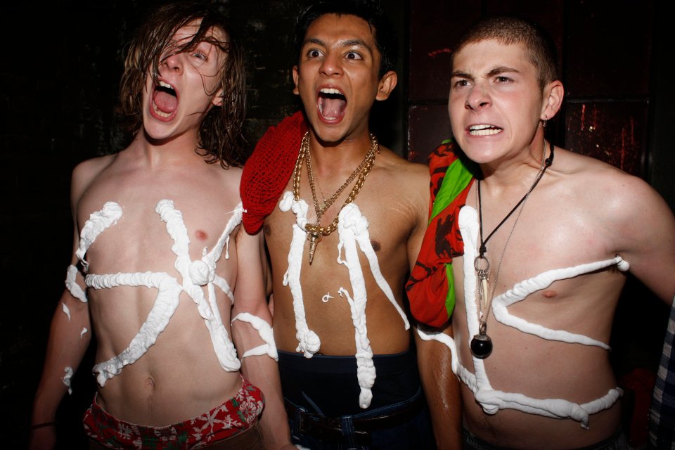 Three shirtless men with shaving cream on their torsos.