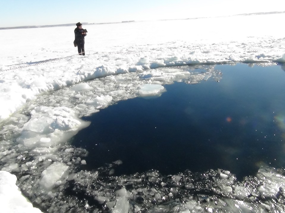 Hole in ice where a meteor struck Chebarkul Lake, Russia.