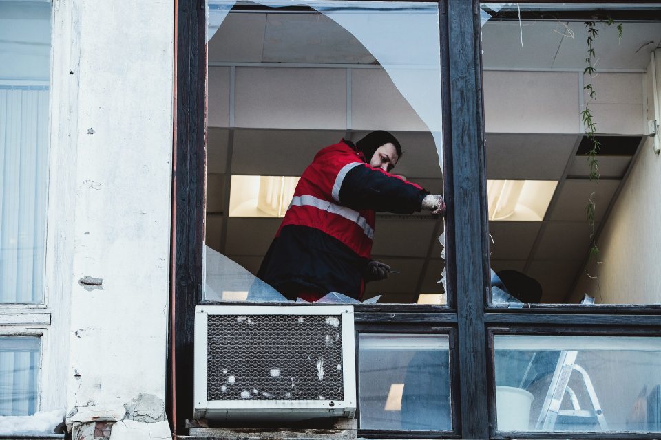 A worker removes broken glass from a window after a meteorite struck Chelyabinsk, Russia.