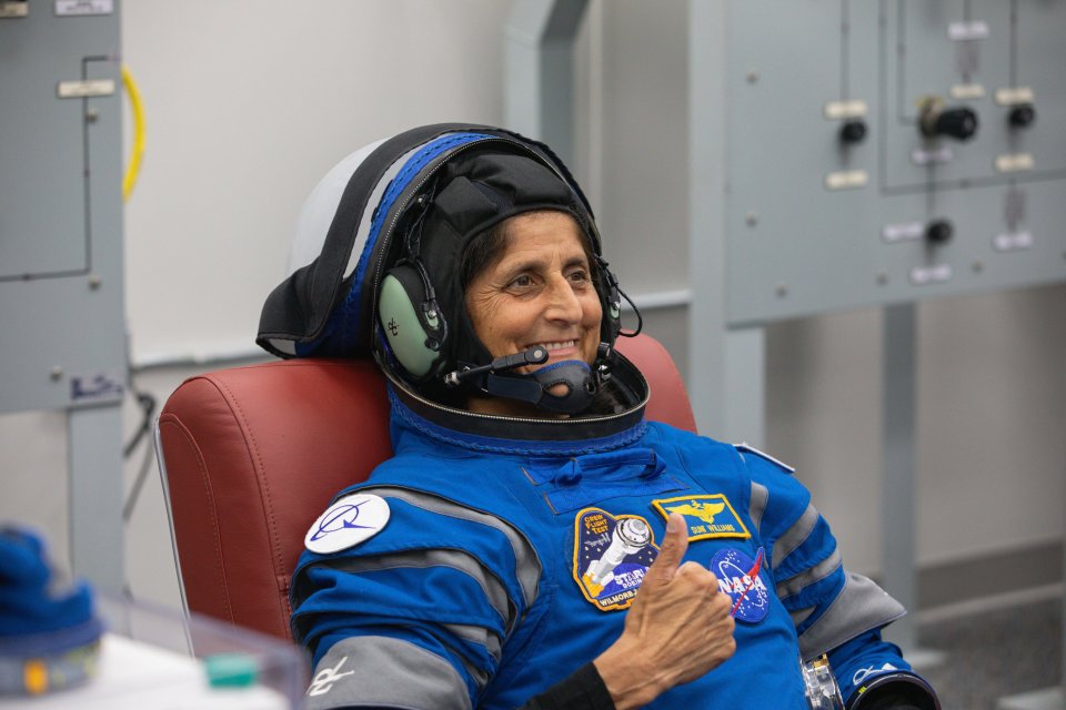 Astronaut Suni Williams gives a thumbs up while in a spacesuit.