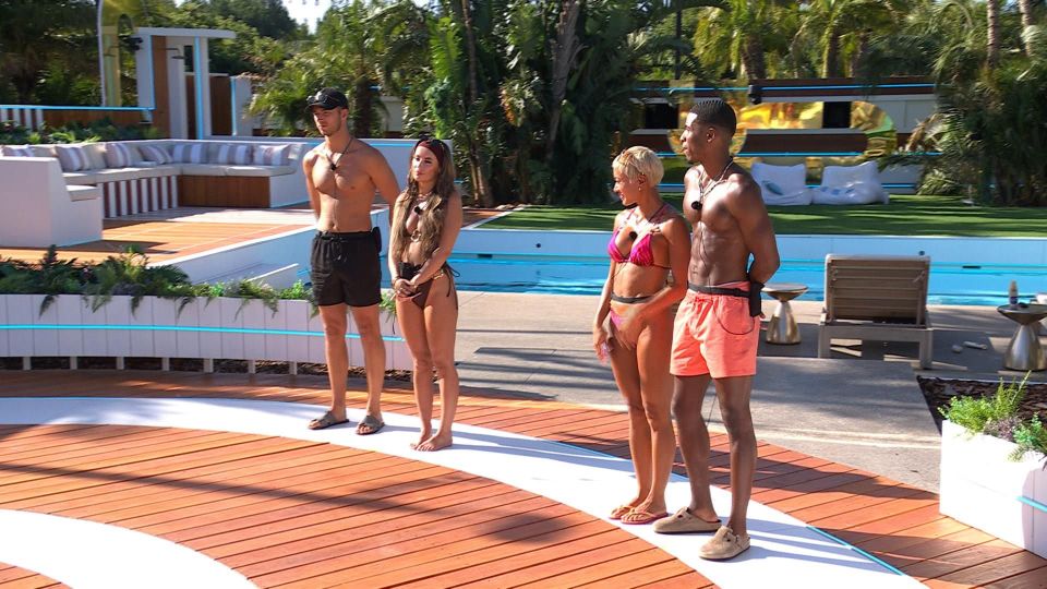 Four Love Island contestants standing on a deck by a pool.