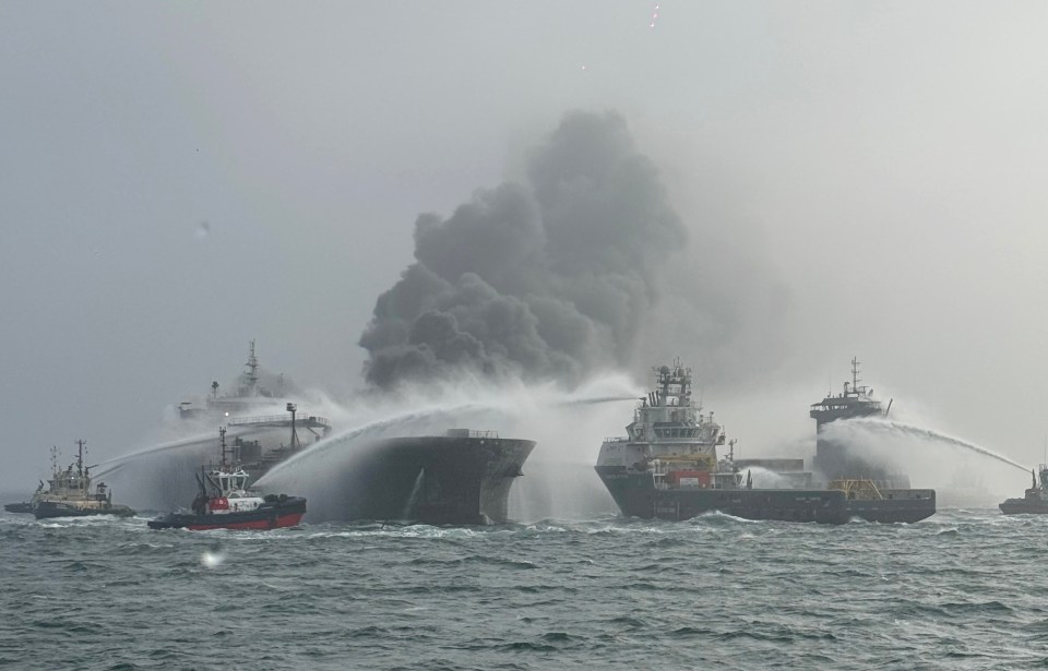 Oil tanker fire being extinguished at sea.