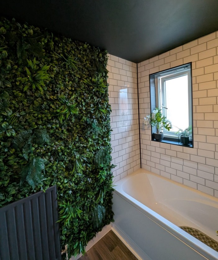 Bathroom with a green wall and a bathtub.