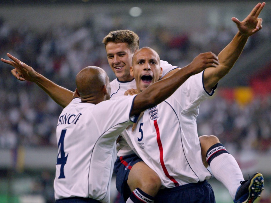 NIIGATA, JAPAN:  English players defender Trevor Sinclair (L) and forward Michael Owen (2nd L) congratulate their teammate defender Rio Ferdinand (C) after he scored his team's first goal during the second round match Denmark/England of the 2002 FIFA World Cup in Korea and Japan, 15 June 2002 at Niigata Big Swan Stadium.  AFP PHOTO  YOSHIKAZU TSUNO (Photo credit should read YOSHIKAZU TSUNO/AFP via Getty Images)