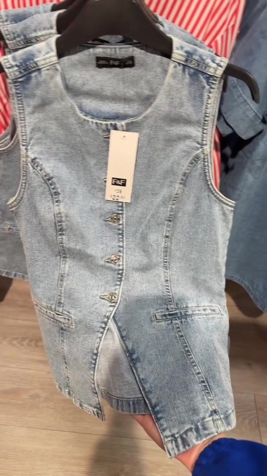 Light wash denim vest with buttons.