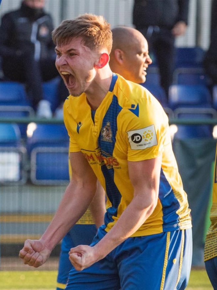 A soccer player in a yellow and blue uniform celebrates.