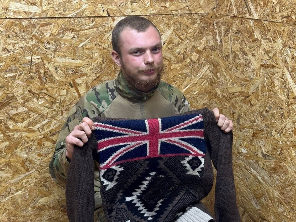 Captured British mercenary James Scott Rhys Anderson holding a sweater with a Union Jack.
