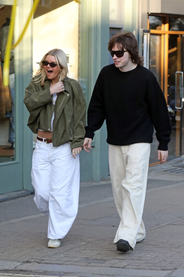 Gene Gallagher holding hands with a woman while walking down the street.