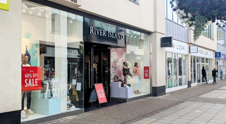 River Island and New Look stores in a shopping center with sale signs.