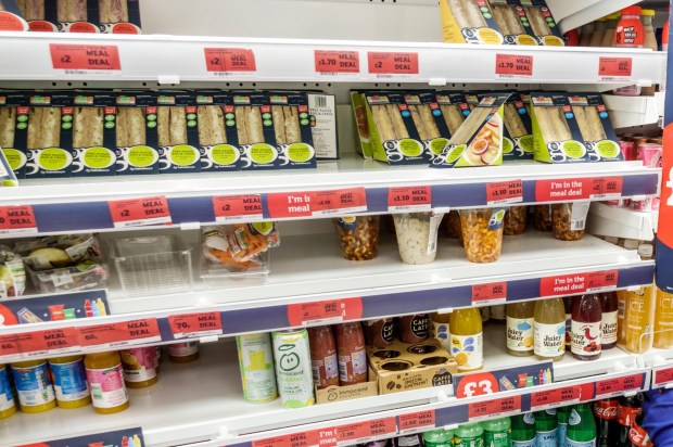 Sainsbury's employee stocking shelves in a supermarket.