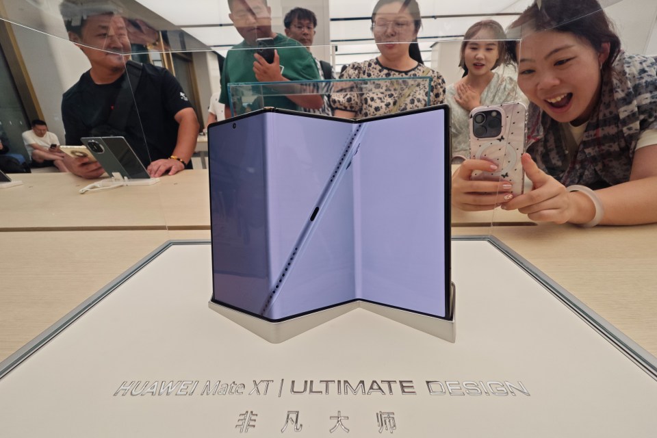 Triple-folding Huawei Mate XT phone on display in a store.