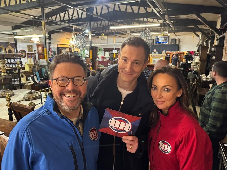 Three people posing for a photo, holding a Bargain Hunt sign.