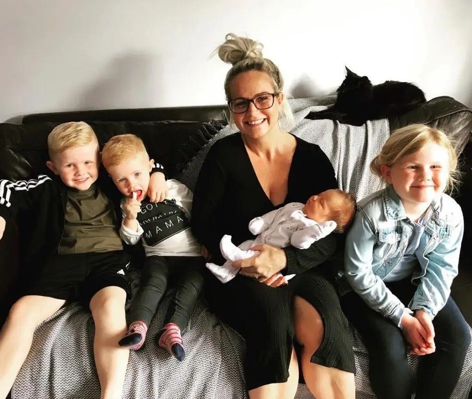 Mother with four young children on a couch.