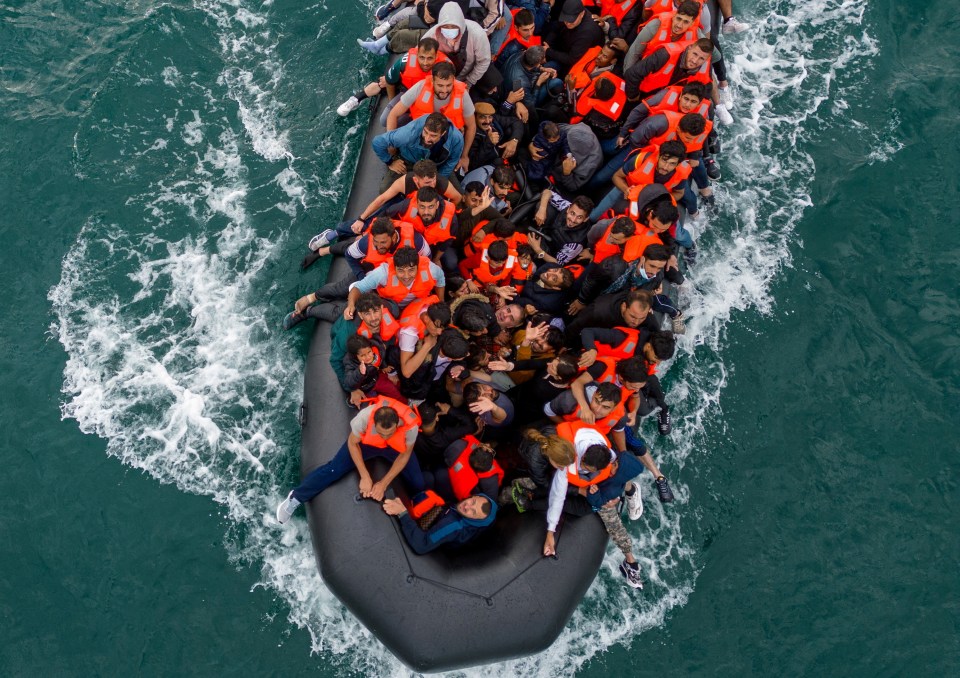 Aerial view of migrants in an inflatable dinghy at sea.