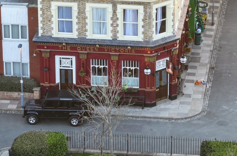 The Queen Victoria pub, newly rebuilt, with flowers outside.
