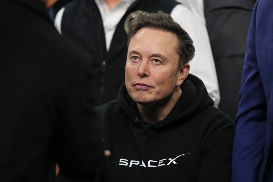Elon Musk at the NCAA wrestling championship wearing a SpaceX hoodie.