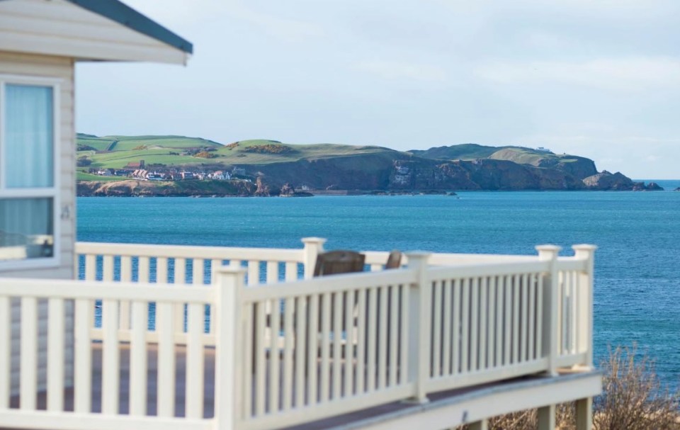 Ocean view from a deck with a white railing.