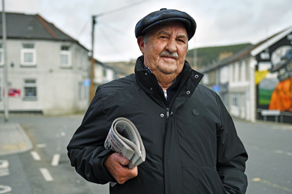 75-year-old Tony Evans holding a newspaper in Maerdy, South Wales.