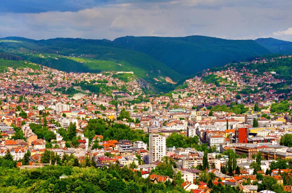 Aerial view of Sarajevo, Bosnia and Herzegovina, nestled in a valley surrounded by mountains.