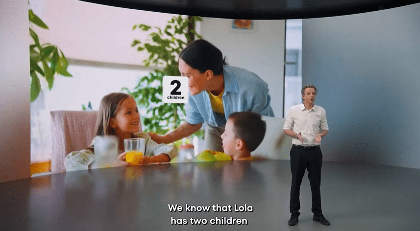 A man presenting a screen showing a woman with two children, illustrating how AI knows personal details.