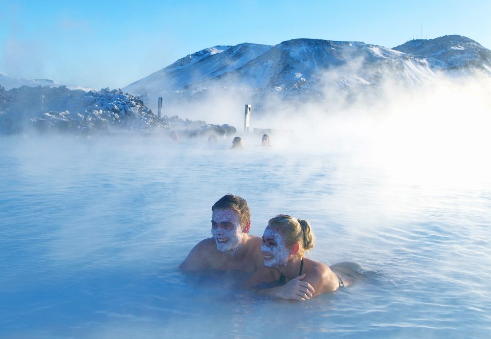 Couple relaxing in a geothermal hot spring in Iceland.