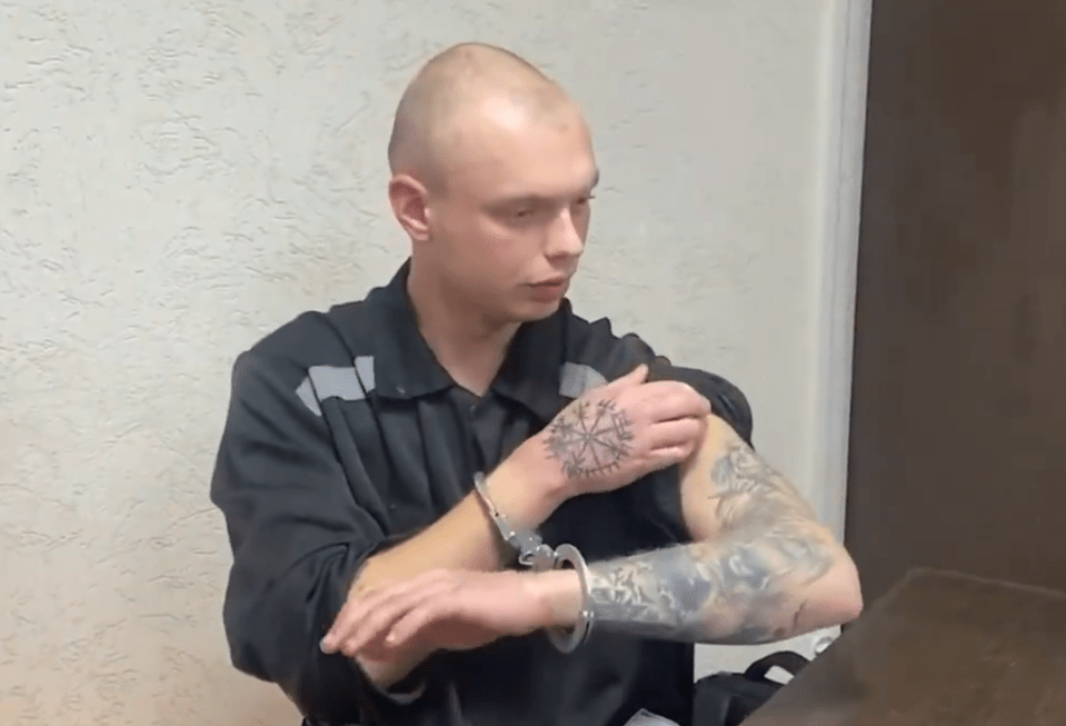 A handcuffed man with tattoos showing a Vegvisir on his hand.