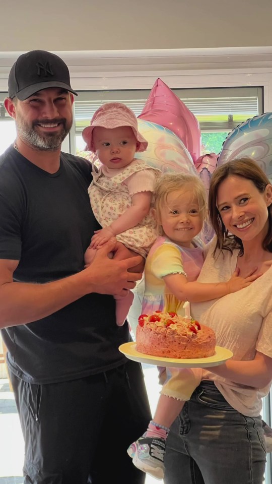 Family celebrating a birthday with cake and balloons.