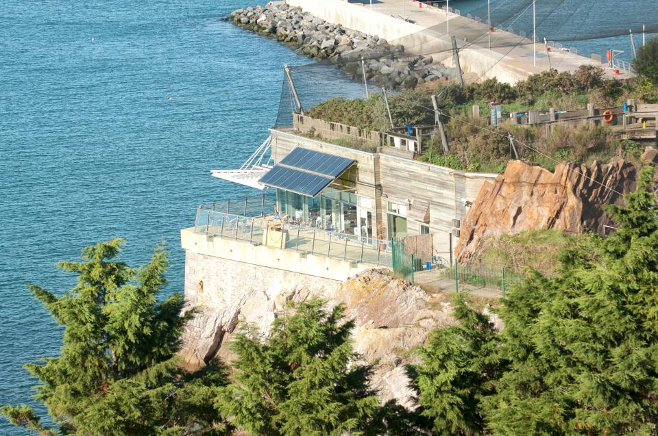 Aerial view of a seaside attraction building with solar panels.