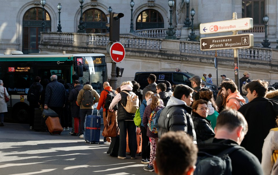 Passengers queueing for a bus to Charles de Gaulle Airport due to train service disruption.