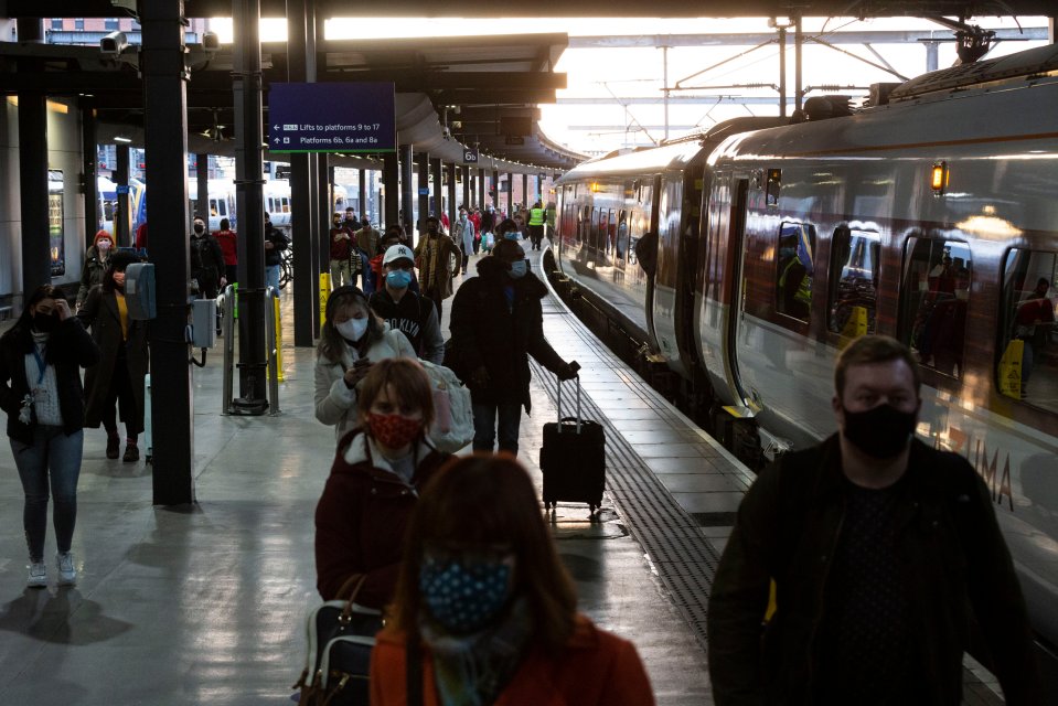 Passengers wearing masks travel on a train.