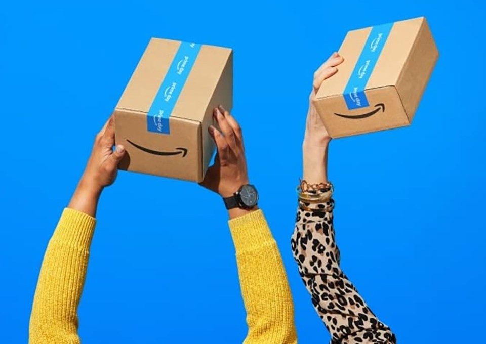 Two hands holding up Amazon Prime boxes.