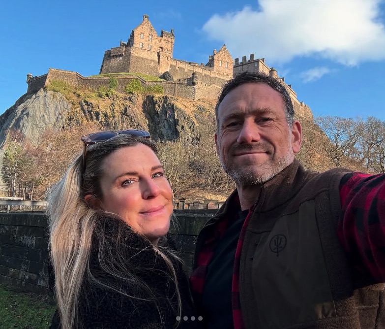 Couple posing for a selfie in front of Edinburgh Castle.