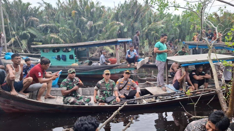 People on boats searching a river in Indonesia.