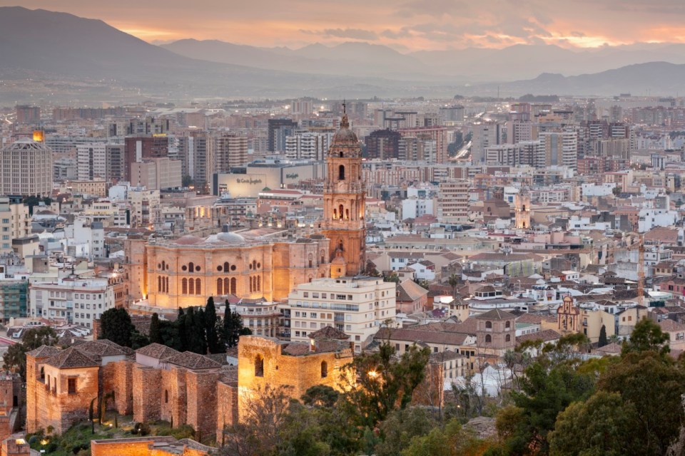 Malaga City, Spain, Europe. Malaga Cathedral and the walls of Alcazaba at dusk. Elevated view