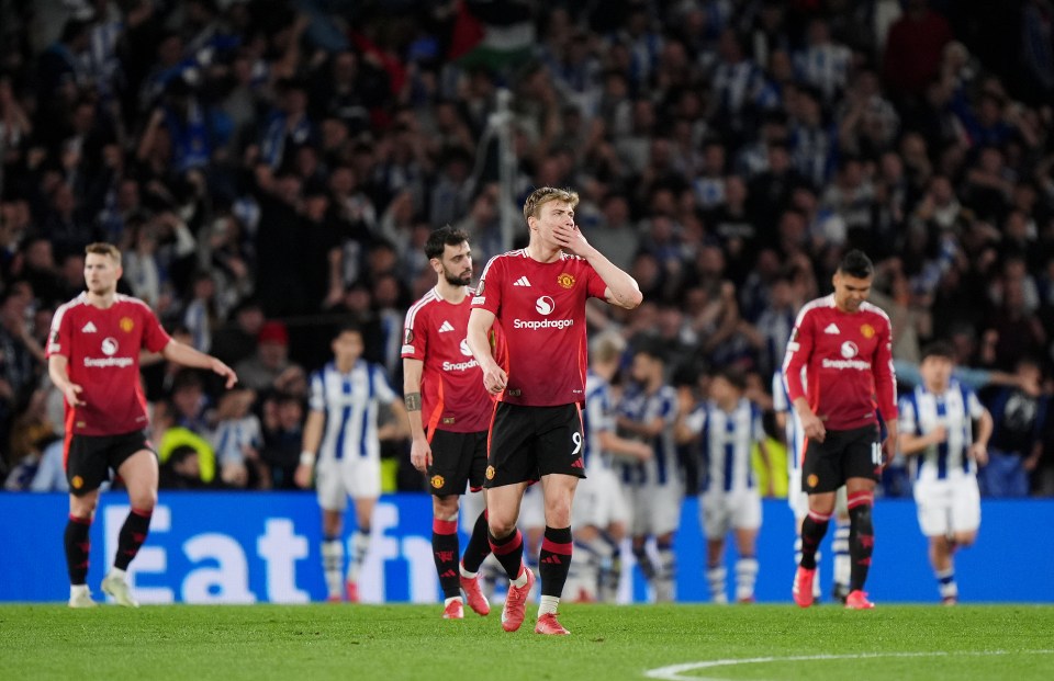 Manchester United soccer players looking dejected on the field.
