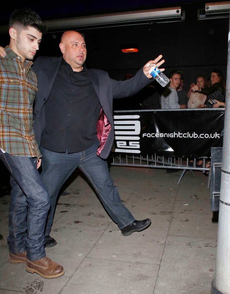 Zayn Malik leaving a nightclub, assisted by security.
