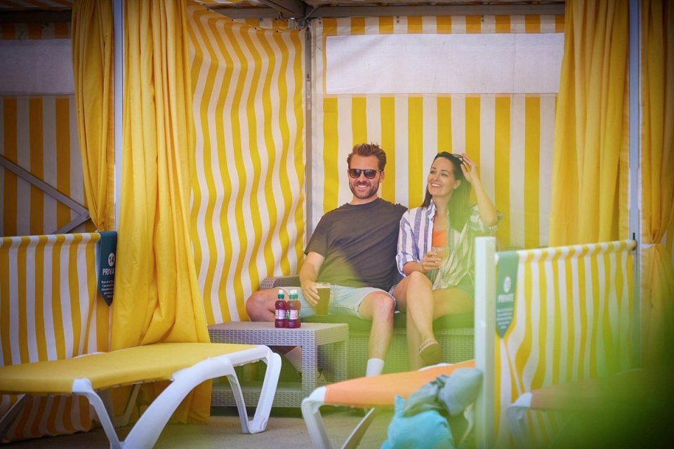 Couple relaxing in a private cabana by the pool.