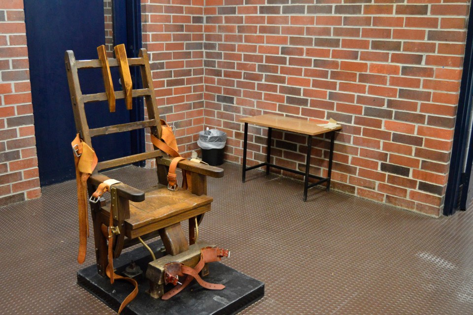 Electric chair in a brick room.