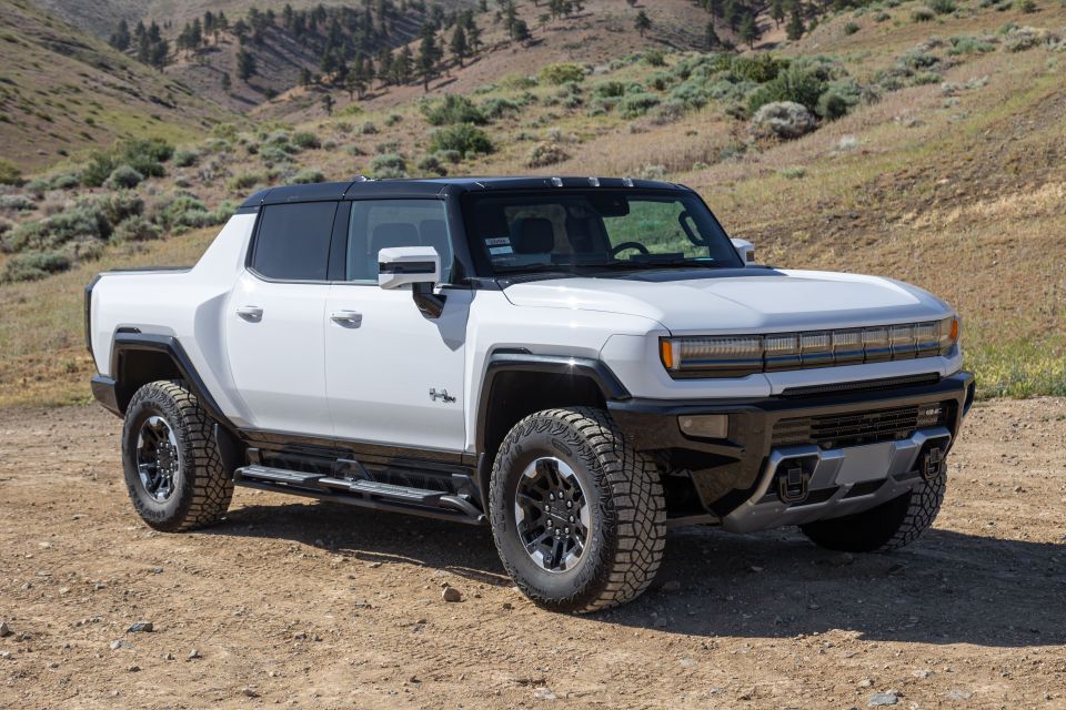 White GMC Hummer EV on a dirt road.
