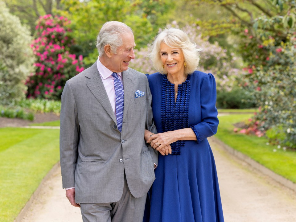 King Charles and Queen Camilla walking in Buckingham Palace Gardens.