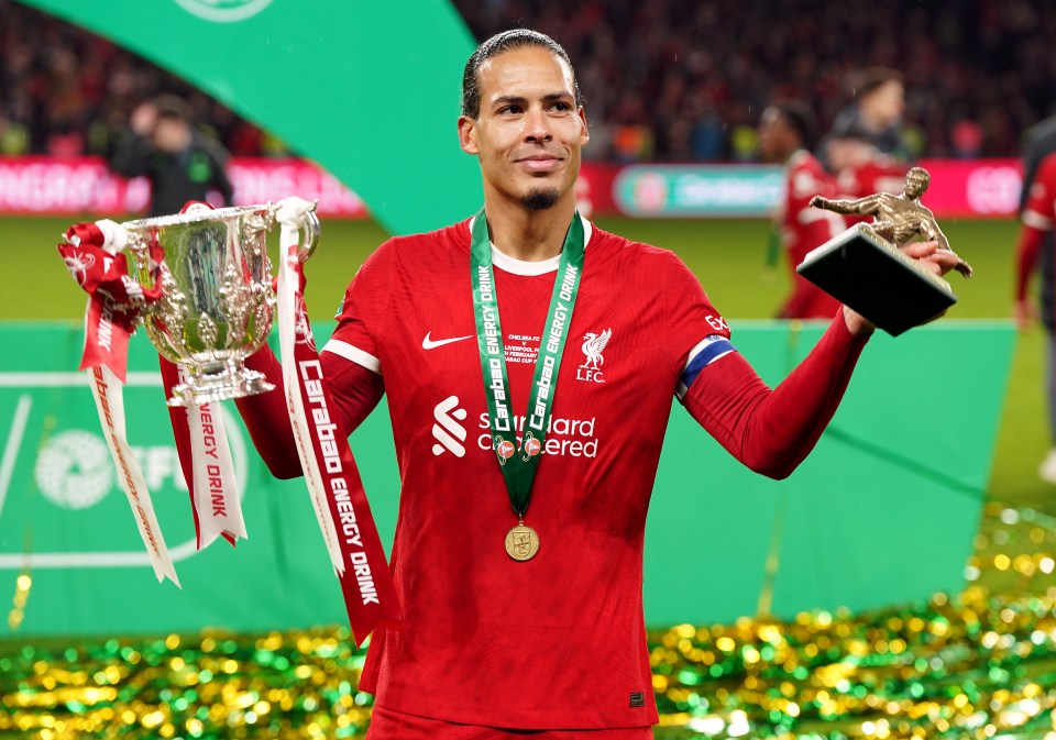 Virgil van Dijk holding trophies and medals.