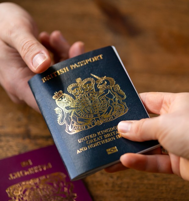 a person handing another person a british passport