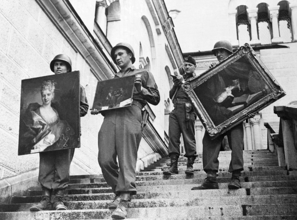 7th Army soldiers carrying Nazi-looted paintings down steps.