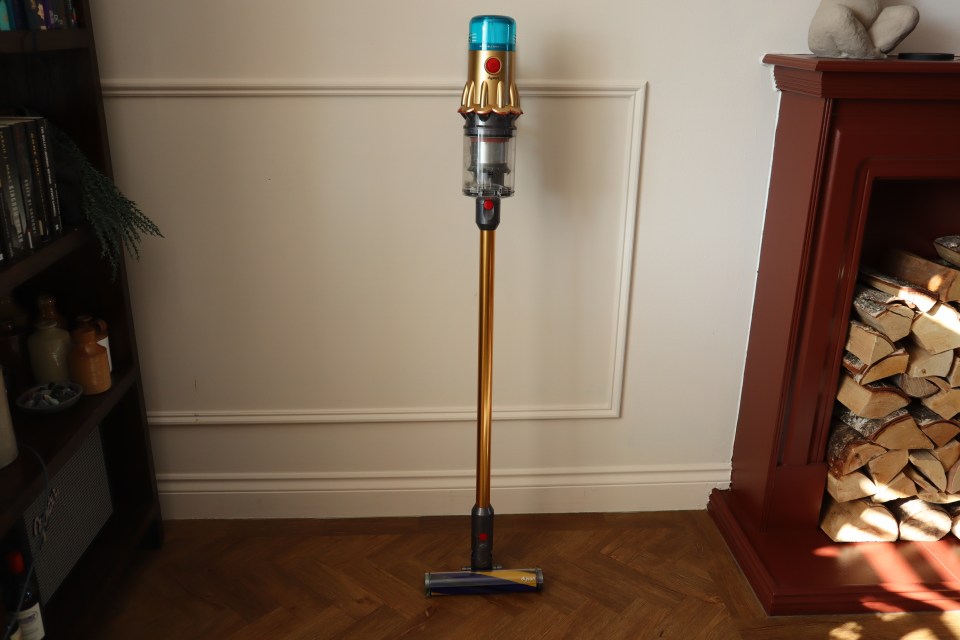 The Dyson V12 Detect Slim Absolute vacuum cleaner standing on hardwood floor.