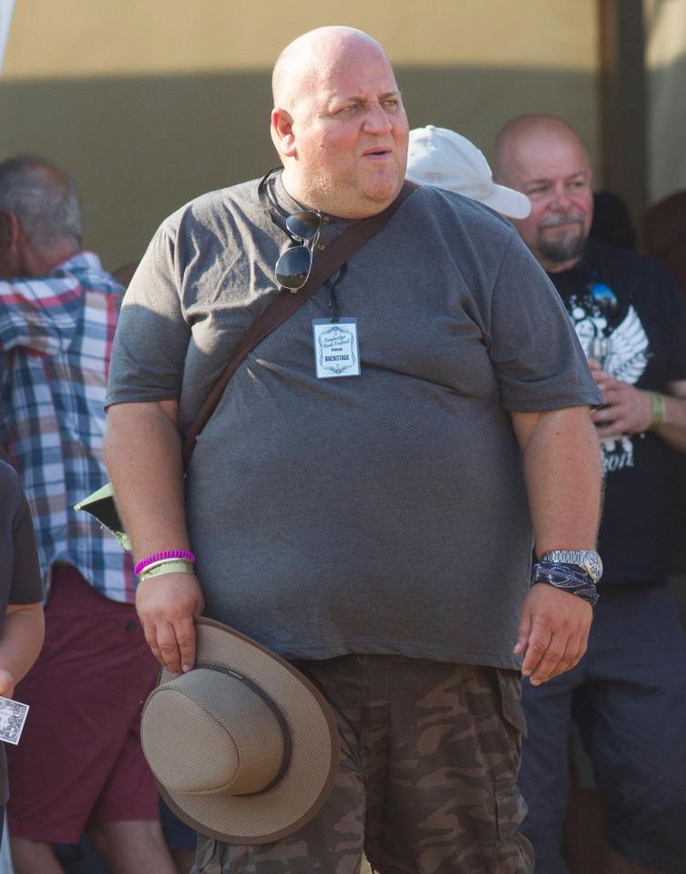 A man at a music festival with a backstage pass.